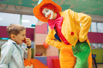 Funny clown animator dancing with little boys