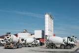 Fototapeta  - White concrete mixers standing by a modern concrete plant.