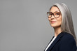 © LIGHTFIELD STUDIOS - elegant asian businesswoman with grey hair in eyeglasses isolated on grey