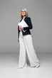 © LIGHTFIELD STUDIOS - attractive asian businesswoman with grey hair holding laptop on grey