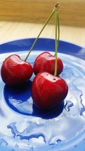 Close-up Of Red Cherries On Wet Plate At Table