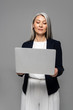 © LIGHTFIELD STUDIOS - attractive asian businesswoman with grey hair using laptop isolated on grey