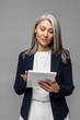 © LIGHTFIELD STUDIOS - serious asian businesswoman using digital tablet isolated on grey