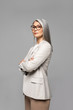 © LIGHTFIELD STUDIOS - beautiful asian businesswoman in eyeglasses with crossed arms isolated on grey