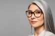 © LIGHTFIELD STUDIOS - attractive asian businesswoman in eyeglasses isolated on grey