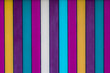 A fun brightly colored stripey background with blues, whites, purples, yellows and teal shades in vertical stripes