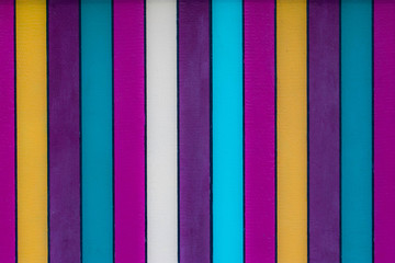 A fun brightly colored stripey background with blues, whites, purples, yellows and teal shades in vertical stripes