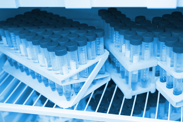 transparent flasks with blue caps with chemicals in the refrigerator in the laboratory in blue light