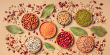 Legumes Assortment, Overhead Panoramic Shot On A Brown Background. Lentils, Soybeans, Chickpeas, Red Kidney Beans, Black-eyed Peas, A Vatiety Of Pulses