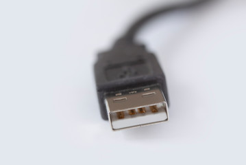 Macro photo of black micro usb cord, cable and connector. Shallow depth of field on white background with copy space.