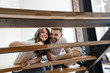 © elemakar - Young couple smiles and looks through the stairs in their home
