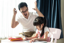 Homeschool Asian Young Little Girl Learning, Reading And Does Homework With Mean Dad Strictly  Teaching Encourage. Father Angry  Daughter That Lazy To Study Hard. Family Domestic Parent, Kid Problem.