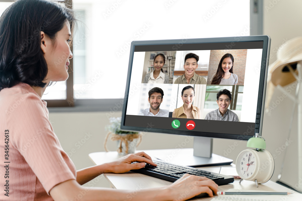 Asian business woman talking to colleague team about plan in video conference. Group of multiethnic business people using computer for online meeting in video call conference. Smart working from home. - obrazy, fototapety, plakaty 