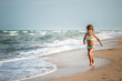 © YouraPechkin - Joyful little girl enjoys a beach day while relaxing at sea on a sunny warm summer day. Summer vacation and relaxation concept