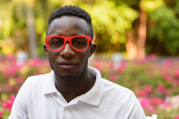 Wall Mural - Face of young African man with eyeglasses at the park outdoors