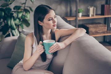 Sticker - Profile side photo of calm peaceful quiet girl sit divan look hold tasty coffee cup dream plan ponder think life in living room interior house indoors