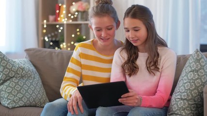 Canvas Print - people, technology and friendship concept - happy teenage girls with tablet computer sitting on sofa at home