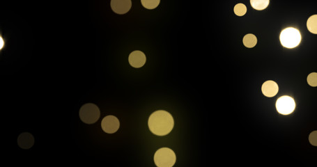 Leinwandbilder - Bokeh light background, gold shine abstract particles with blur flare effect. Golden glitter glowing shiny bokeh light sparkles on black background