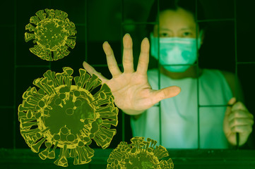 Quarantine to stop coronavirus epidemic, Blurred woman wearing face mask and holding hand up to stop coronavirus behind fence toned in green color