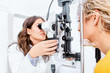 © Karanov images - Optometrist giving Slit lamp examination of the eyes in ophthalmology clinic
