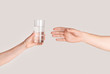 © Prostock-studio - Young girl giving glass of fresh clear water to man on light background, closeup of hands. Panorama
