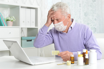 Sticker - Ill senior man with facial mask using laptop