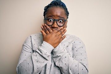 Sticker - Young african american plus size woman with braids wearing casual sweatshirt and glasses shocked covering mouth with hands for mistake. Secret concept.