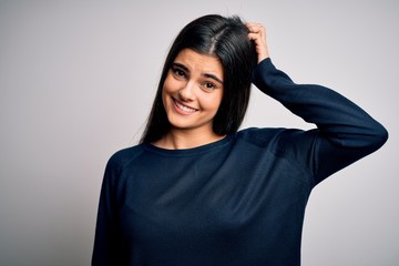 Wall Mural - Young beautiful brunette woman wearing casual sweater standing over white background confuse and wonder about question. Uncertain with doubt, thinking with hand on head. Pensive concept.