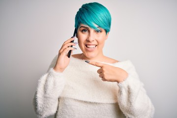 Sticker - Young woman with blue fashion hair having a conversation talking on smartphone very happy pointing with hand and finger