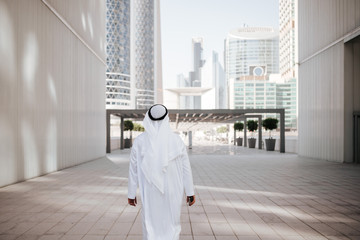 Wall Mural - Emirates urban lifestyle in the big city with Arab guy investor checking out the city in gulf country. Photography of Arabian places and building construction.