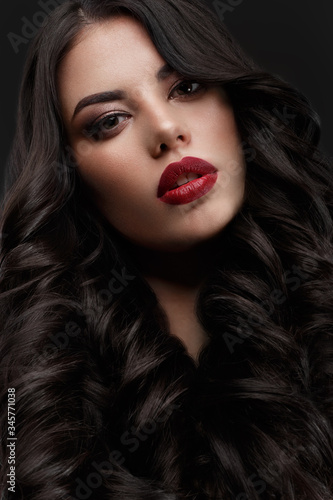 Beautiful brunette model: curls, classic makeup and red lips Fototapet