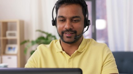 Wall Mural - remote job, technology and people concept - indian man with headset and laptop computer having video conference at home office