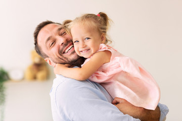 caucasian father holding his cute loving daughter