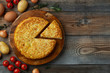 Spanish omelette with potatoes and onion, typical Spanish cuisine. Tortilla espanola. Rustic dark background. Top view with copy space