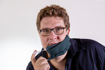 Blond man in glasses with homemade mask for protection against coronavirus isolated on white background