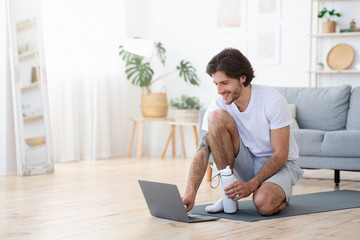 Cheerful young man after online fitness lesson