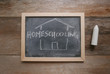 Top view of a chalkboard written with Homeschooling on wooden background.