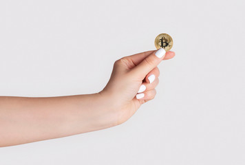 Poster - Close up of millennial woman holdng bitcoin on light background