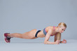 © satyrenko - Young hardy sporty woman does plank isolated on grey background