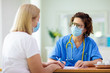 © famveldman - Doctor examining sick patient. Ill woman in clinic
