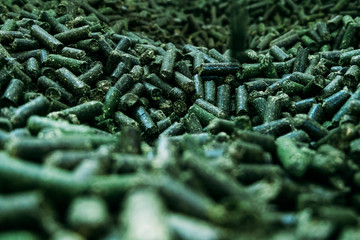 Wall Mural - a large number of alfalfa green granules in a warehouse for the production of agricultural feed