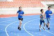 © TinPong - Young Asian boy and girl running on blue track in summer.