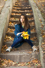 Wall Mural - Pretty brunette little girl posing in autumn park background