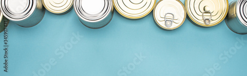 Fotografía top view of cans on blue background with copy space, food donation concept