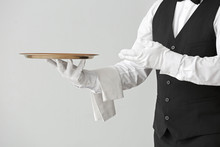 Male Waiter With Empty Tray On Grey Background
