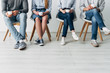 © LIGHTFIELD STUDIOS - Cropped view of colleagues holding coffee cups on chairs in office