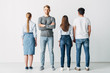 © LIGHTFIELD STUDIOS - Handsome employee looking at camera near young people in office