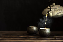 Teapot Pouring Tea Into Cups