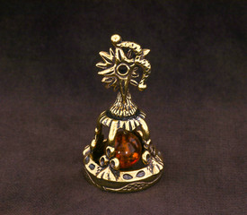 Wall Mural - Amber souvenir. A miniature metal bell in the form of a zodiac sign 