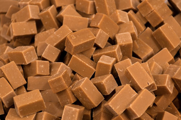 A stack of homemade caramel. Groups of caramel candy, isolated on the table counter at the market.